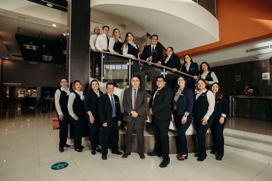 Staff posing by the lobby stairway at Araiza Hotel Hermosillo