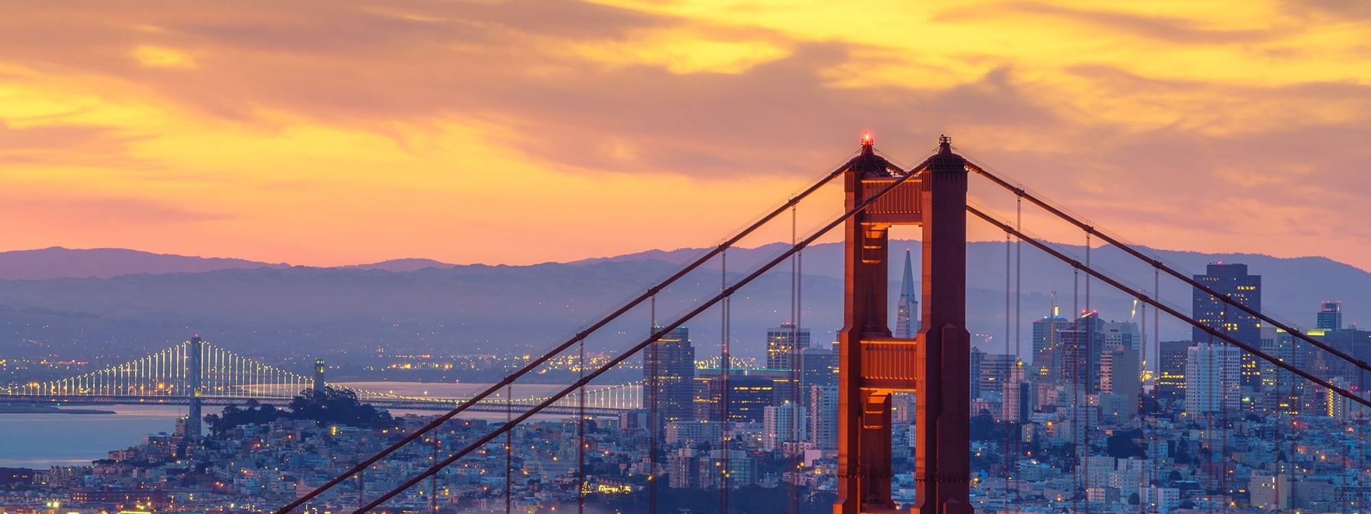 Golden Gate Bridge with city view under evening sky near Warwick Melrose Dallas