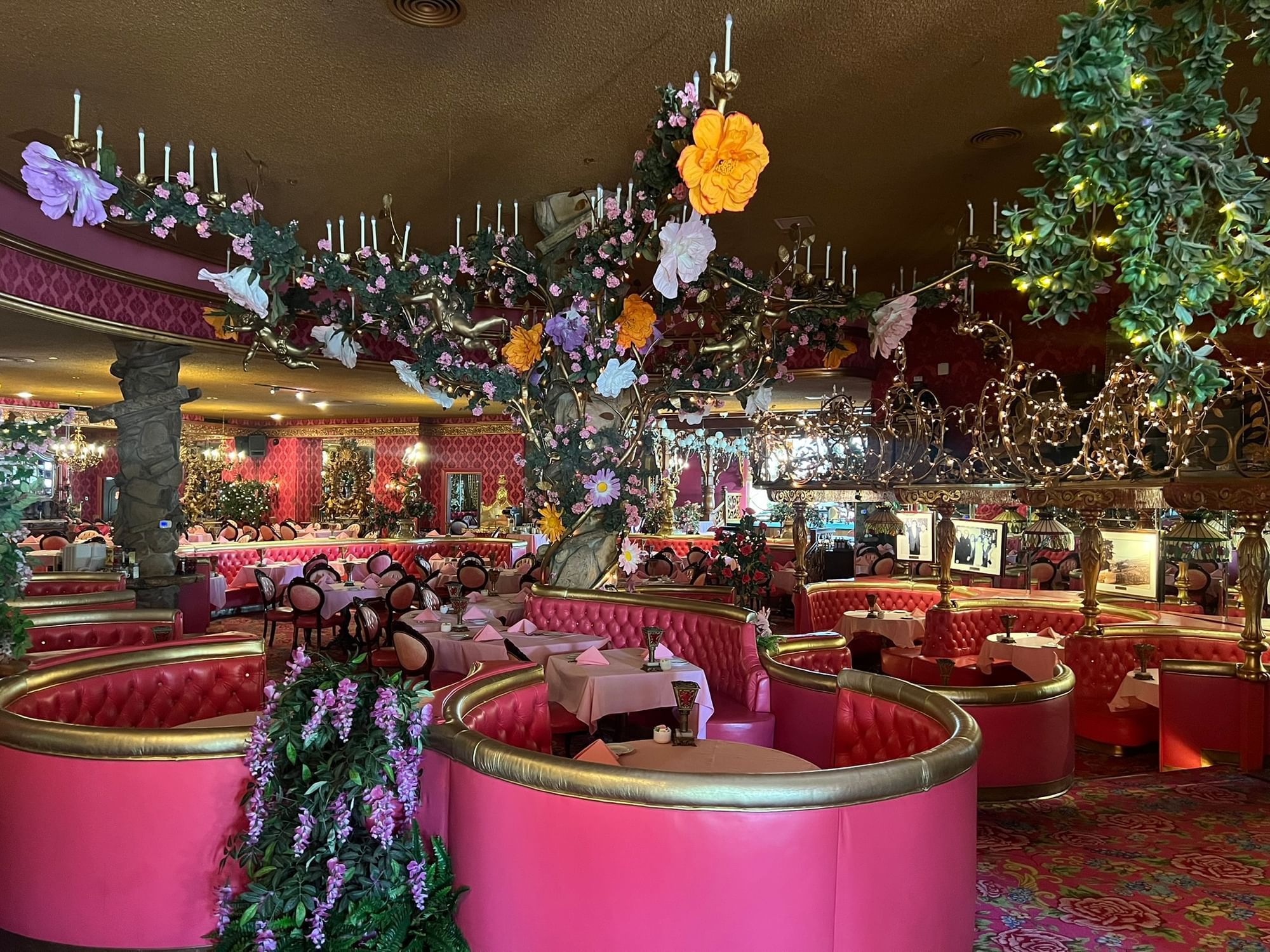 Madonna Gold Rush Steak House interior with pink booths and flowers hanging from the ceiling