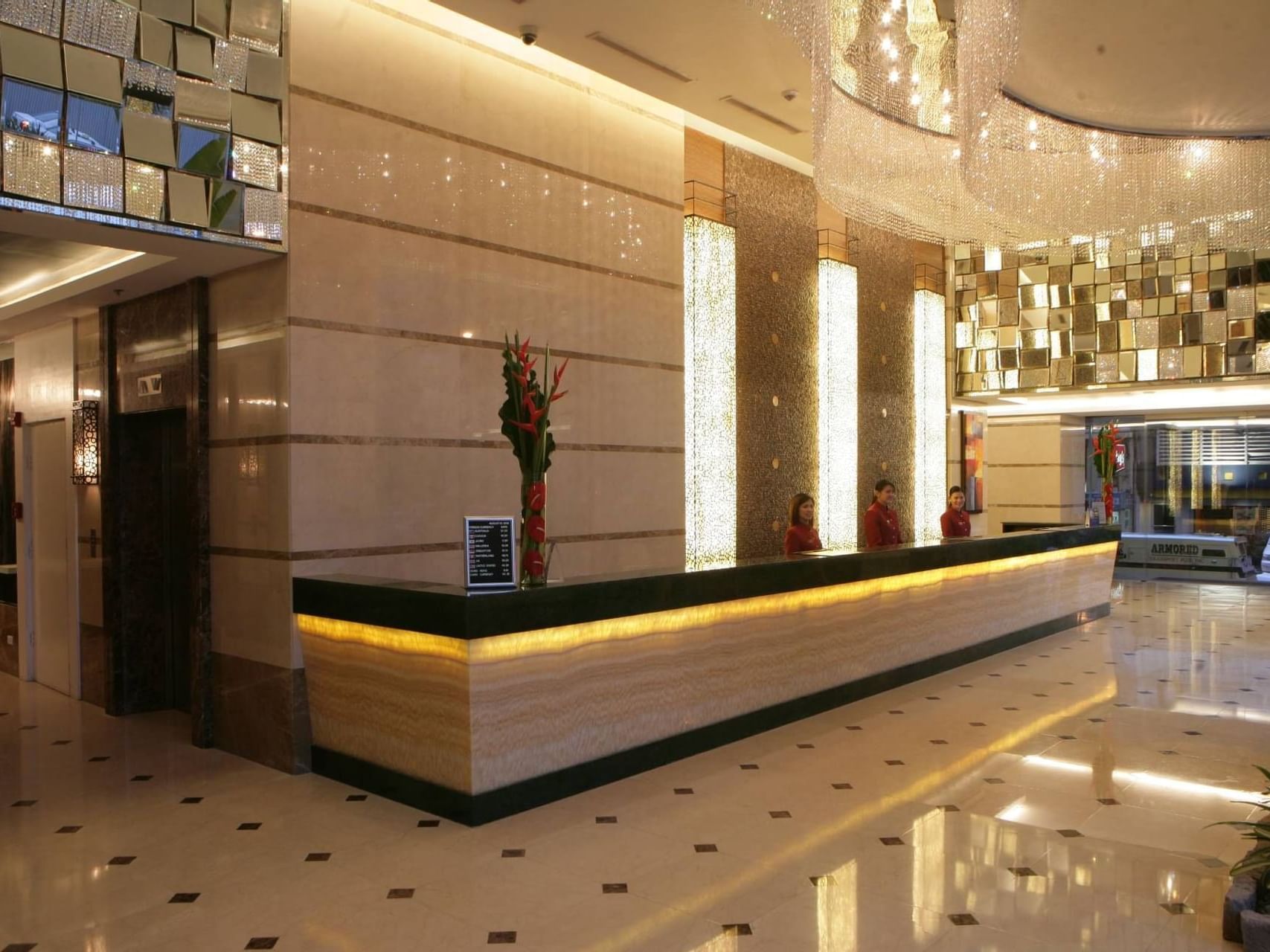 3 receptionists at the reception desk in St Giles Makati Hotel