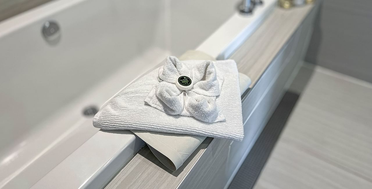 Hotel washroom with bathtub, soap, and towels