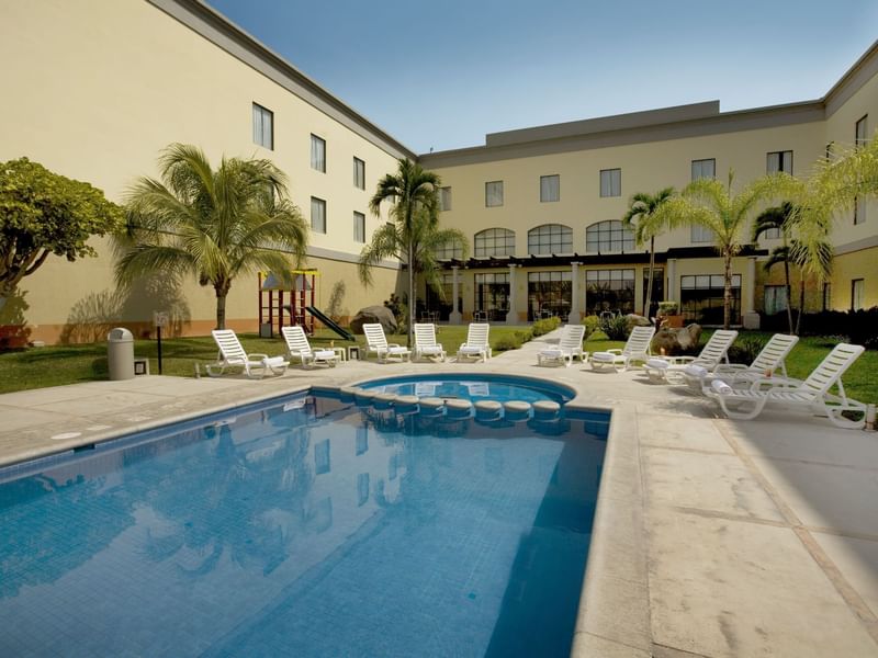 Outdoor swimming pool with pool beds at Fiesta Inn Hotels