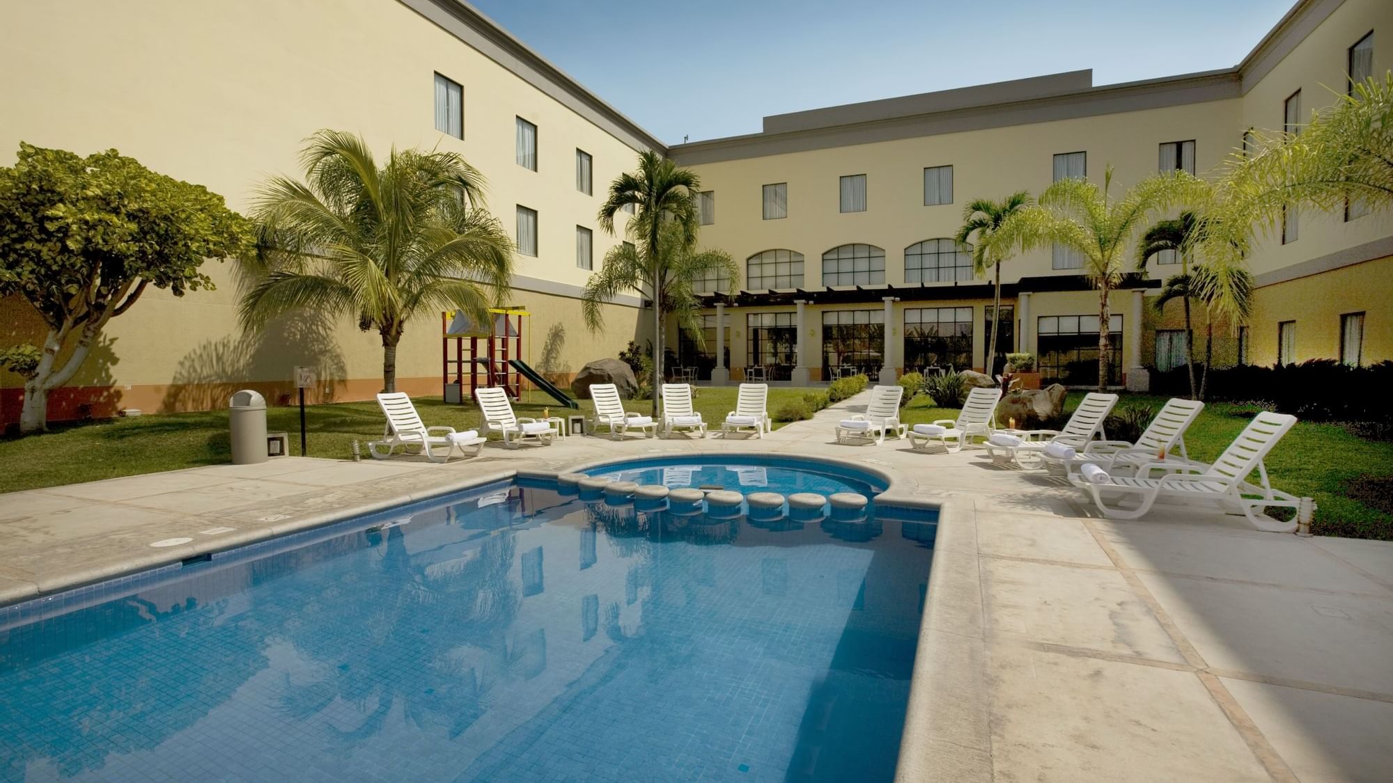 Sunbeds by the outdoor pool at Fiesta Inn Colima