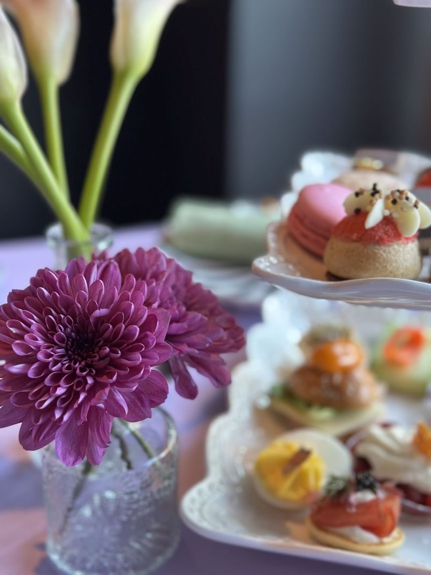 A tiered plate with various desserts on a table, served at the Spring Tea event of the Hotel Arista.