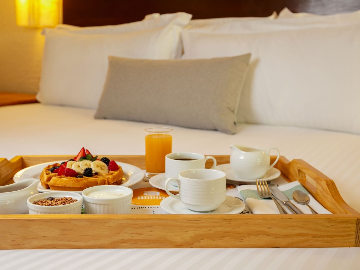Desayuno en cama servido en bandeja de madera en Suite Embajadores King en Camino Real Guadalajara, Zapopan.