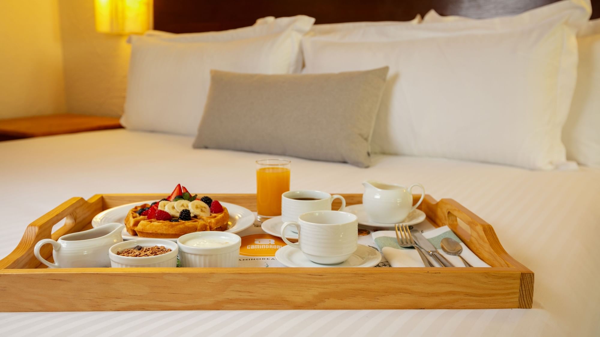 Tray with breakfast on a bed in the King Ambassadors Suite at Camino Real Guadalajara, Zapopan