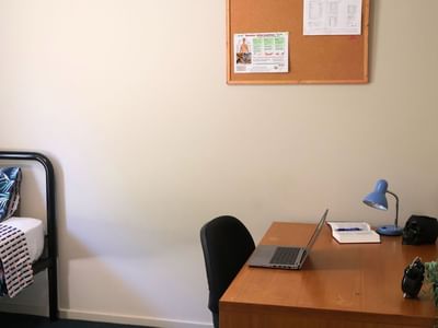 Bedroom with bed, desk, and laptop at La Trobe University - Villas.