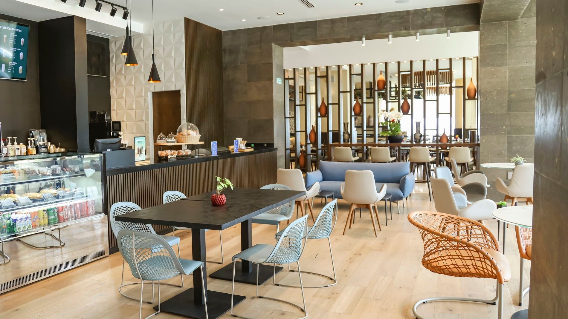 La Huerta cafe lounge with stylish blue chairs, a deli counter, and chic geometric decor at Camino Real Veracruz