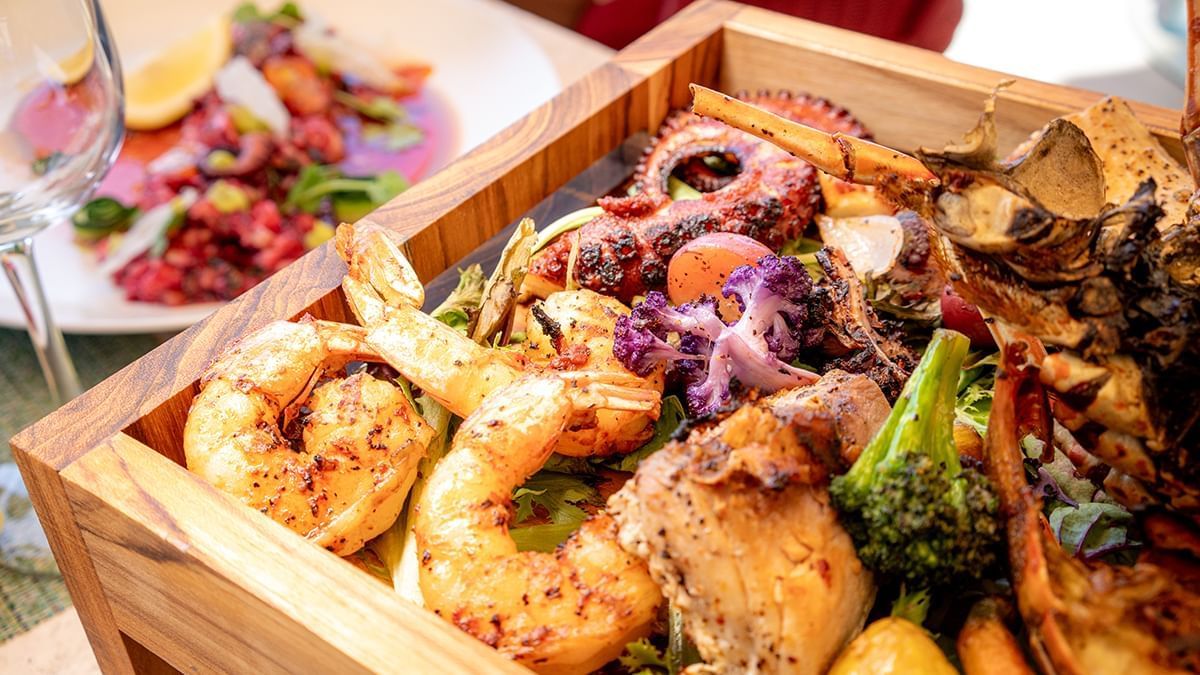 A wooden platter with grilled seafood, vegetables and shellfish at Almar Beach Resort