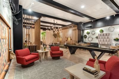 24-Hour Lounge with Games featuring a shuffleboard table, seating, and a lush wall decor at The Riverwalk Plaza Hotel