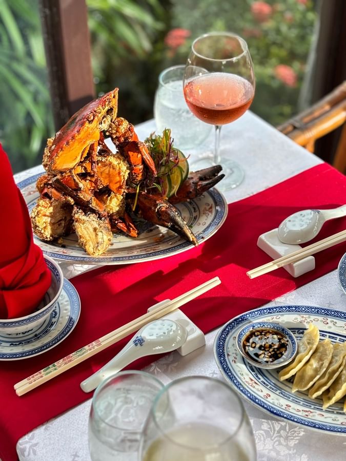 Crab and dim sum on plates with chopsticks and wine at Bamboo Terrace in Korolevu at The Naviti Resort