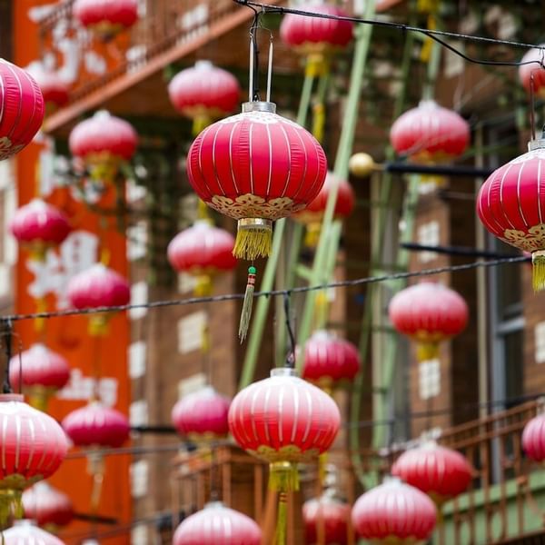Red paper lanterns hanging under a street canopy near Warwick San Francisco