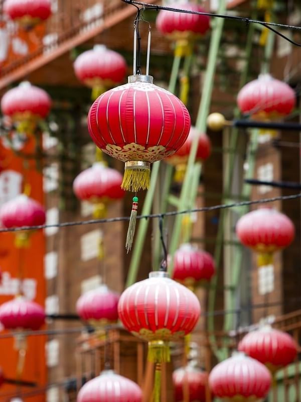 Red paper lanterns hanging under a street canopy near Warwick San Francisco