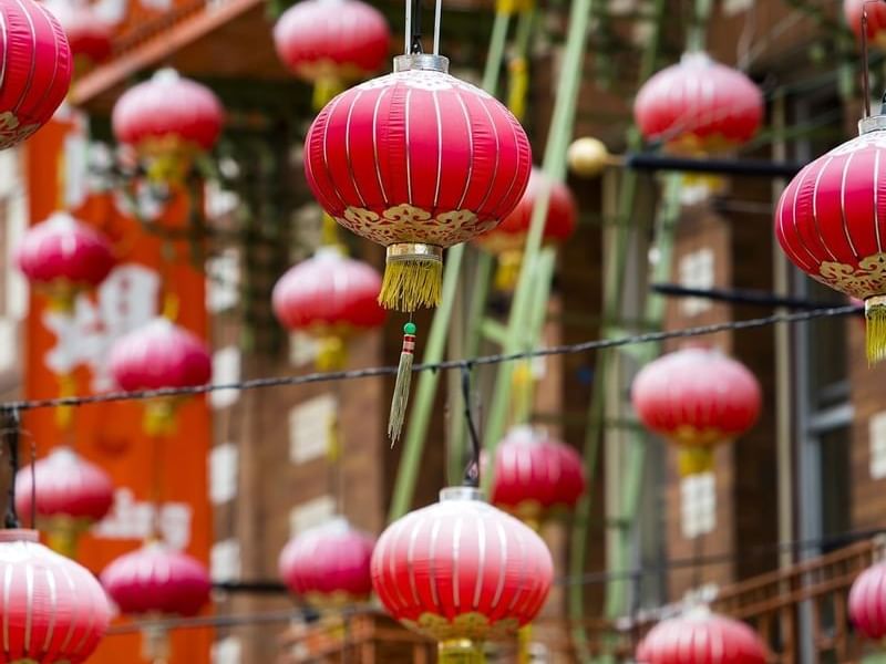 Red paper lanterns hanging under a street canopy near Warwick San Francisco
