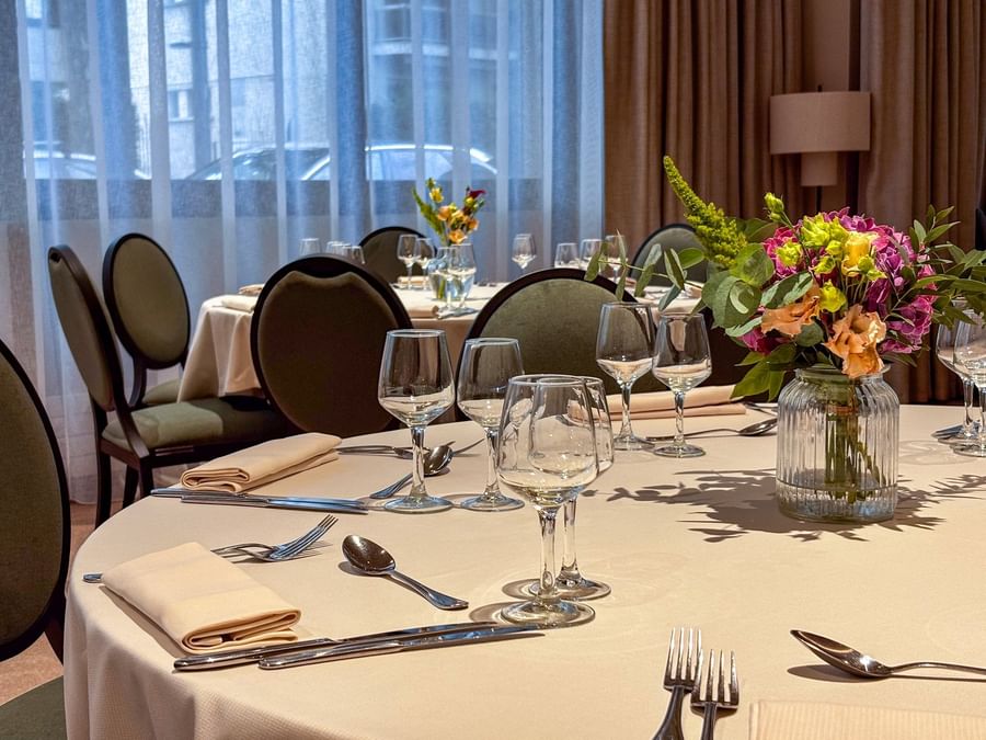 Banquet set-up with floral centerpieces and soft lighting in the Astrid Salon at Warwick Reine Astrid - Lyon