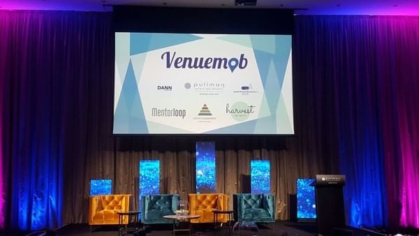 Illuminated meeting room arranged with a stage for speakers at Pullman Albert Park
