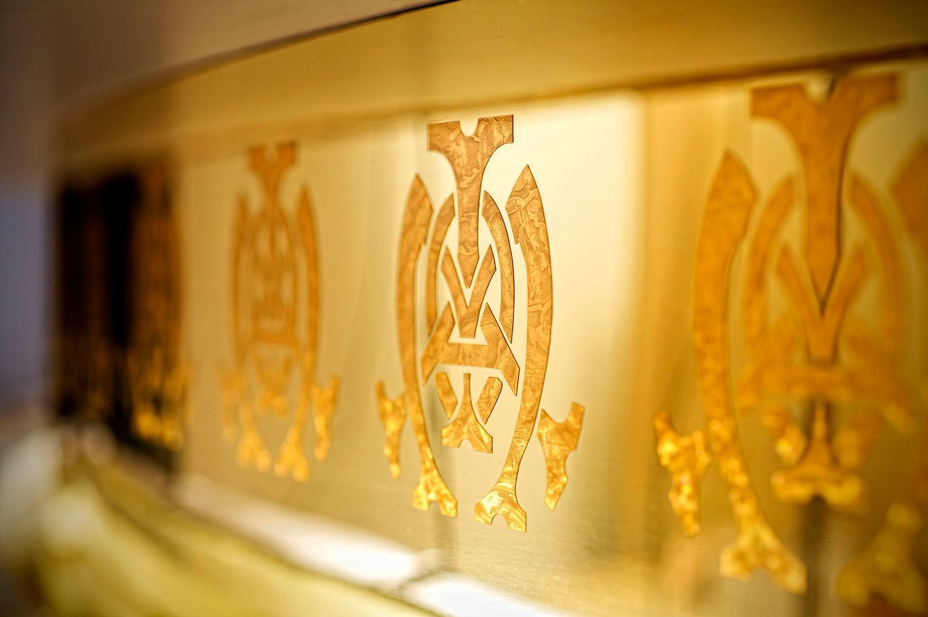 Close-up of Hotel symbols on a gold wall at The Mayo Hotel
