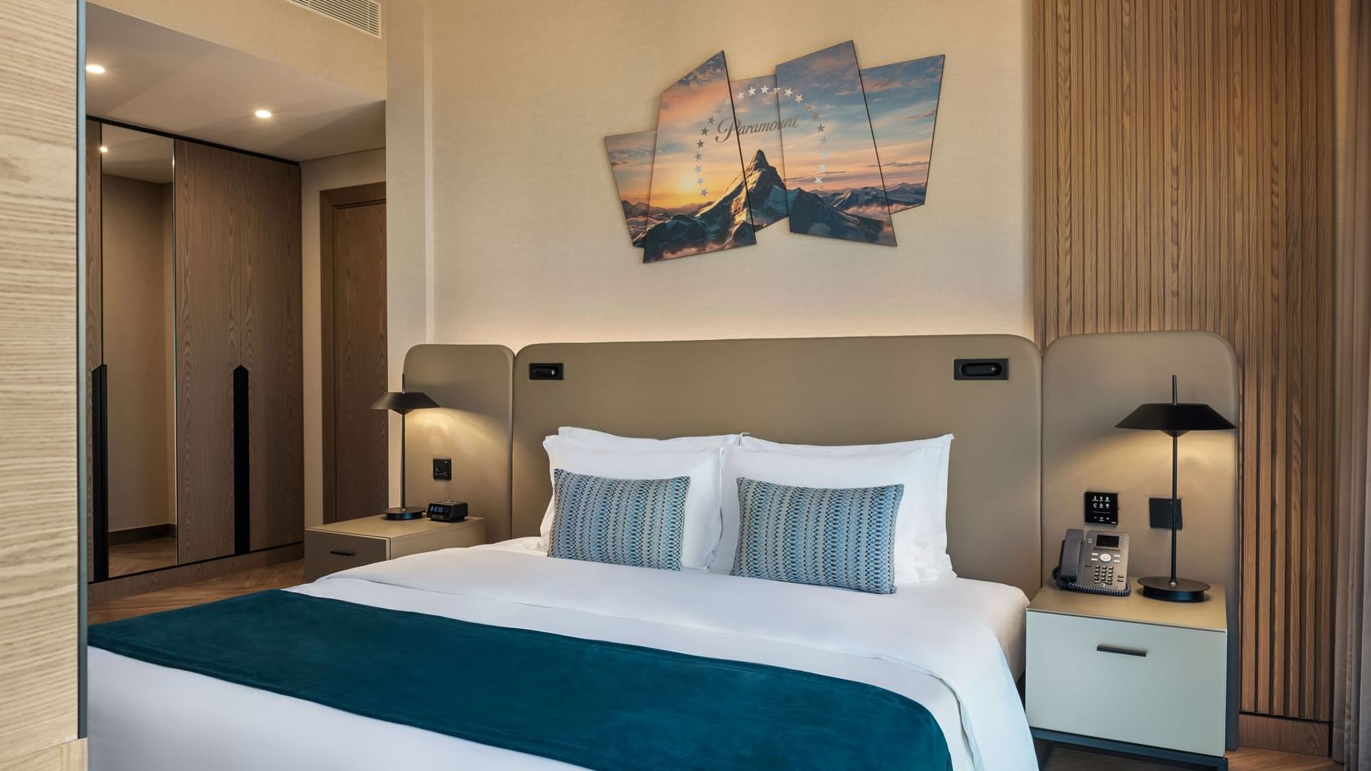 Cozy, elegant bedroom at Paramount Hotel Midtown, featuring a large bed and a Paramount Pictures-themed mountain painting