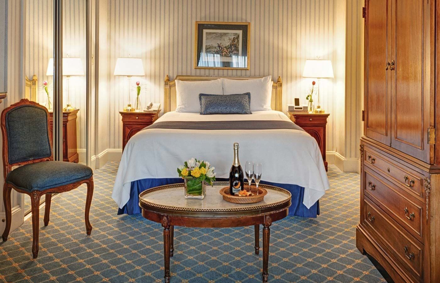 Table de nuit et coin salon près du lit dans une chambre de l'hôtel Elysee de la collection Library Hotel