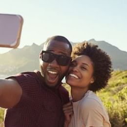 Couple smiling while taking a selfie together near SeaCrest Oceanfront Hotel Pismo Beach