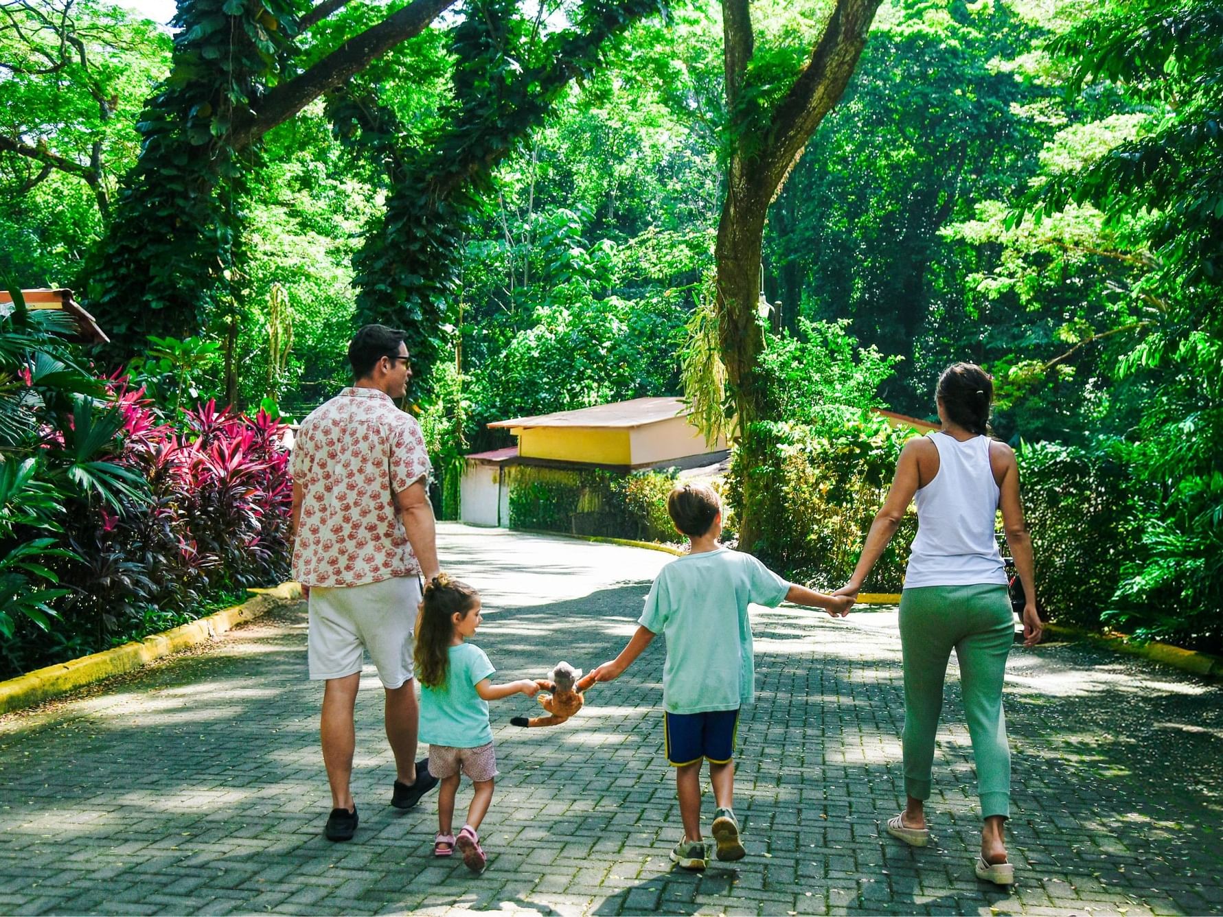 Familia caminando juntos por un sendero rodeado de naturaleza en Vacaciones Familiares