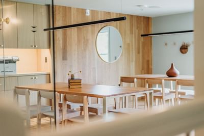 Dining area with wooden furniture, glass partition, and a bright window at The Stonebreaker Hotel