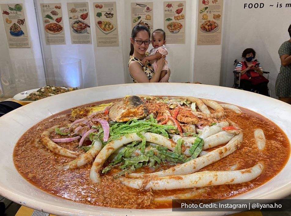 mother and baby taking picture with curry noodle