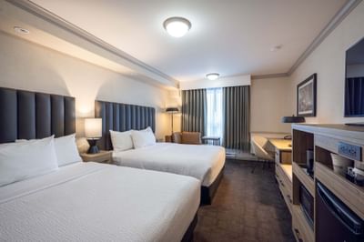 Standard Room with two beds, nightstands, desk, TV and window at Sandman Hotel & Suites Winnipeg Airport, Winnipeg airport hotels