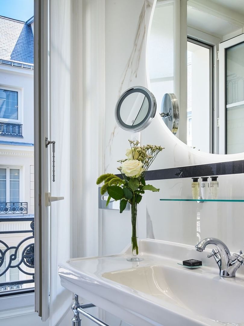 Deluxe Suite Belle Époque bathroom featuring a porcelain sink with a mirror by a window view at Hotel Westminster Paris