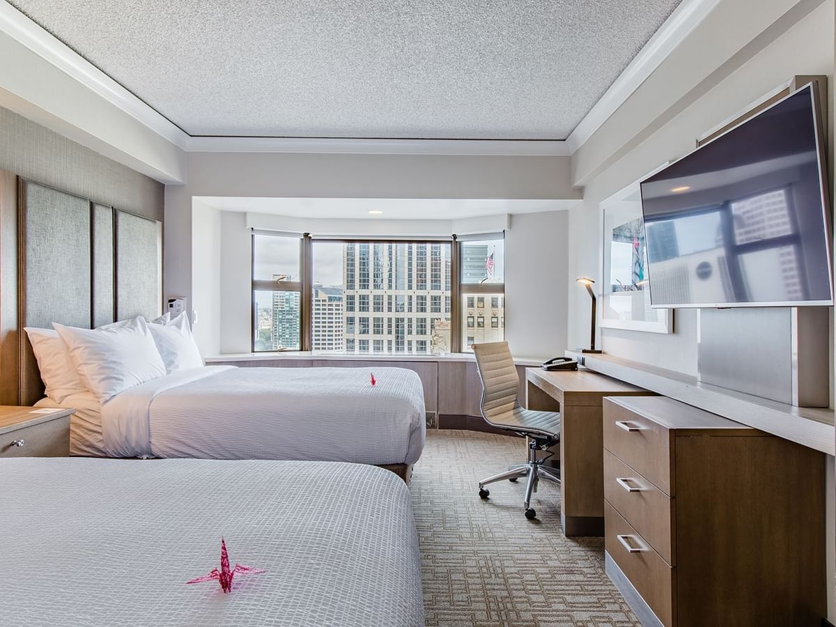 Accessible hotel guestroom with two beds, TV, and desk