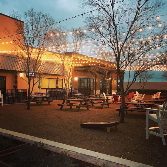 outdoor area with picnic tables and string lights