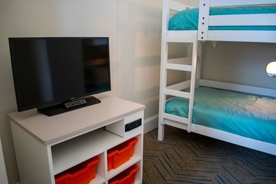 Twin bunk bed and media console with a television in the Kids Suite Oasis Hearing Accessible at Centennial Plaza Resort