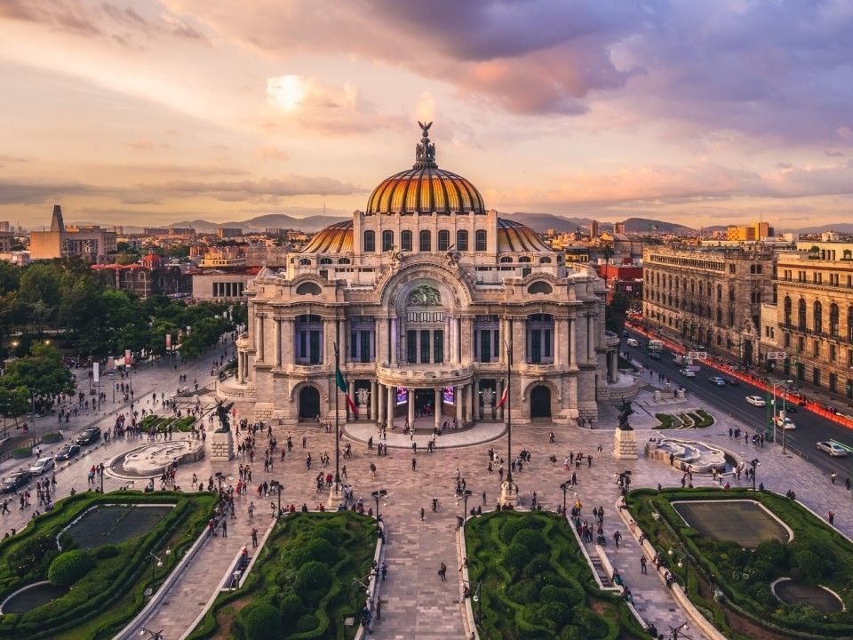 Palace of Fine Arts at dusk featuring a golden dome and manicured gardens near Camino Real Aeropuerto