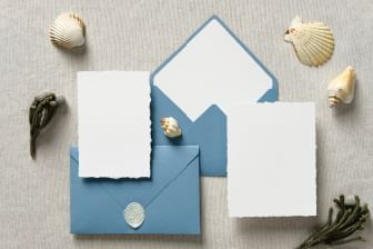 Close-up of wedding invitations with blue envelopes at Sebasco Harbor Resort