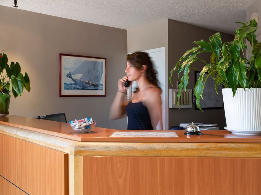 A receptionist at the reception desk in Hotel Le Sextant