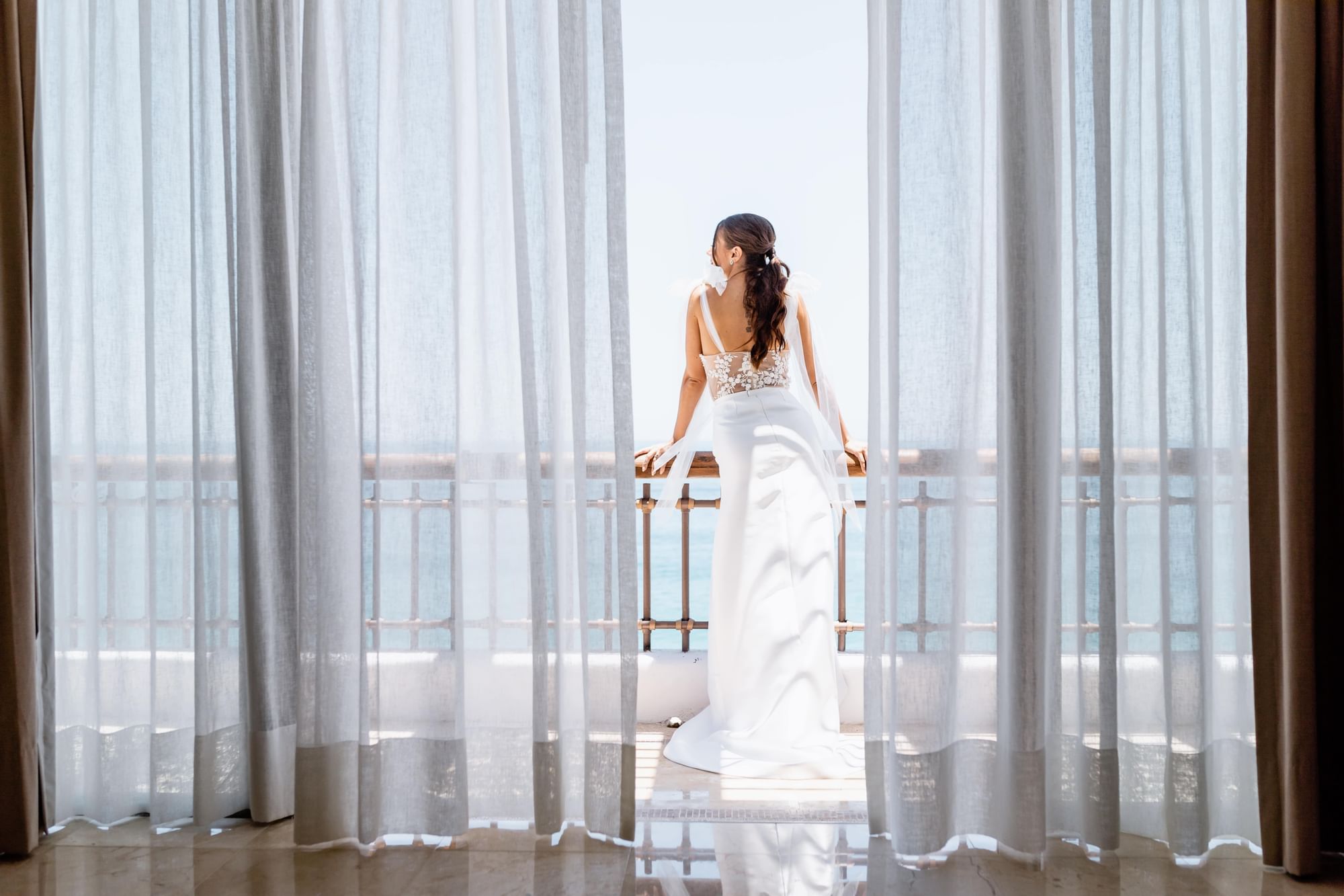 A bride standing on a balcony at Marquis Los Cabos