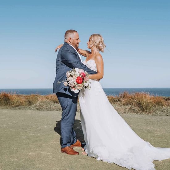 Couple on golf course at Central Coast Wedding venue overlooking ocean