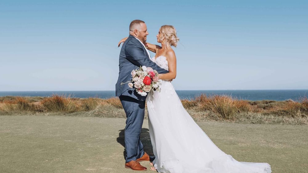 Couple on golf course at Central Coast Wedding venue overlooking ocean