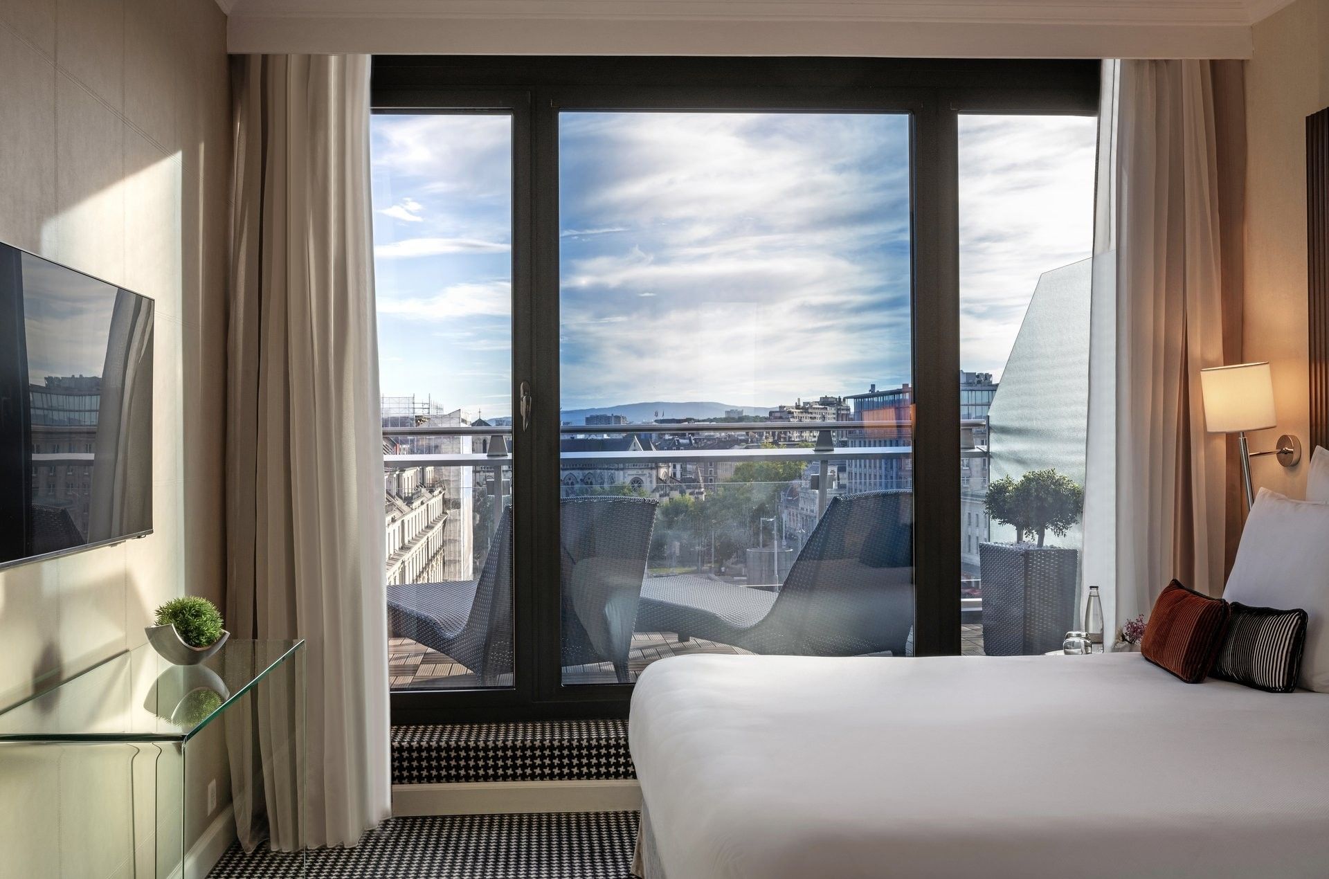 Penthouse Terrace Suite featuring White bed by a glass desk under a tall lamp at Warwick Geneva