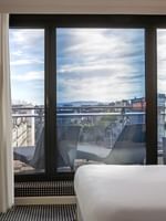 Chambre avec balcon et vue sur la ville au Warwick Geneva à Genève.