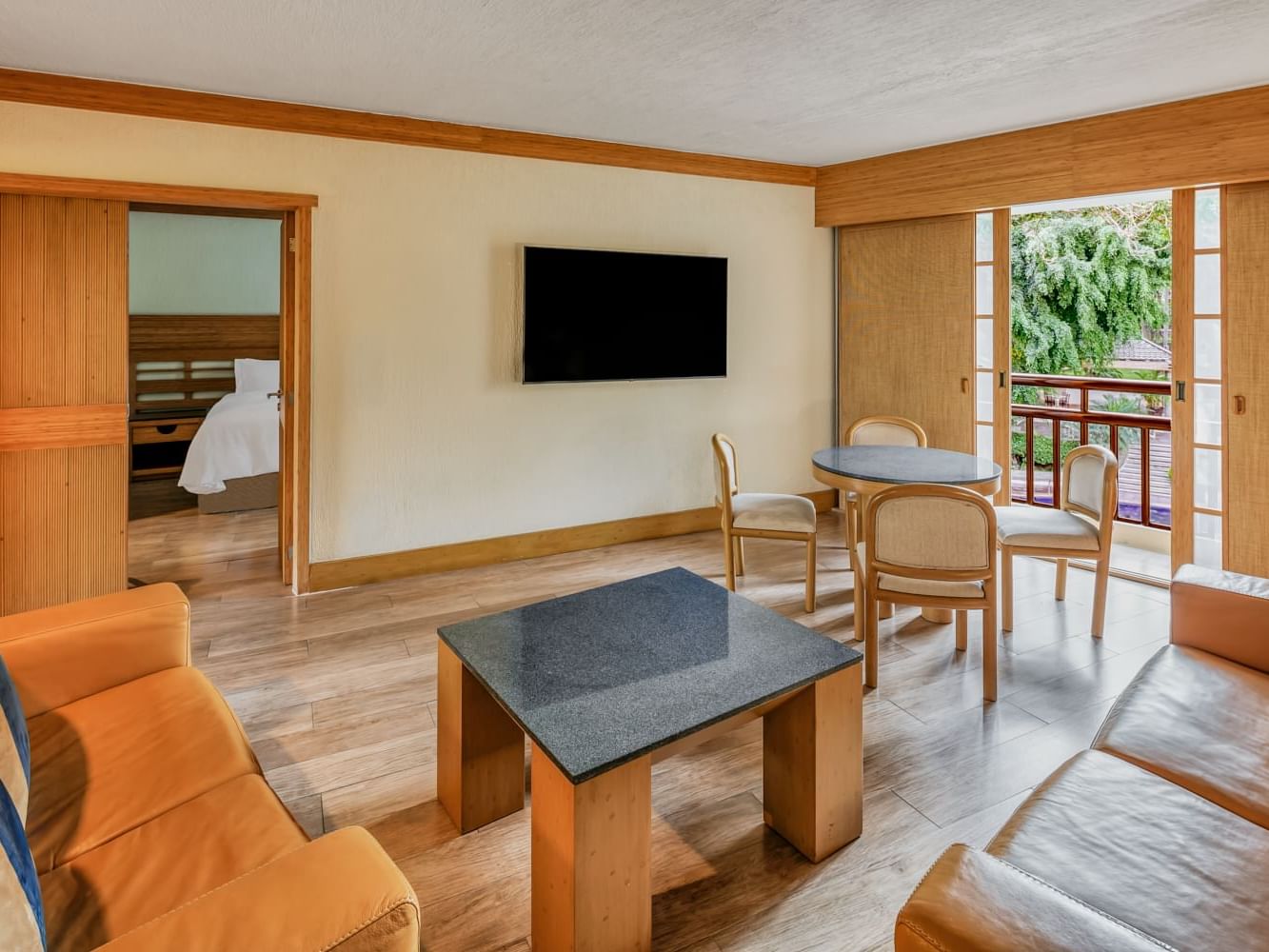 Cozy living area with couches, dining table & TV stand in Junior Suite, 1 King Hotel Sumiya Cuernavaca