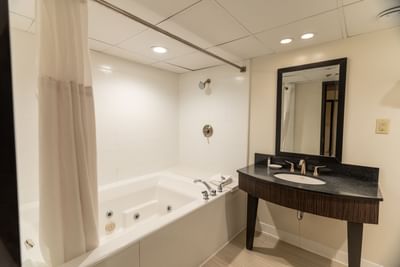 Bathroom bathtub by the vanity in King Jacuzzi Suite at M Hotel Buffalo