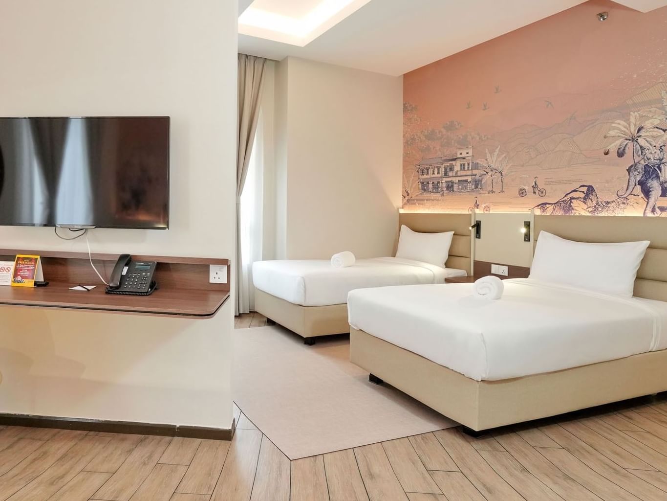 Family Quad bedroom with a large wall mural, TV and wooden floors at Cititel Express Ipoh