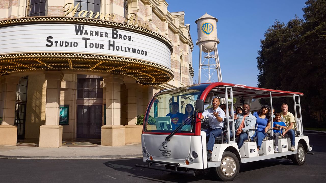 Tourists riding a tour bus in front of the Warner Bros. Studio Tour Hollywood