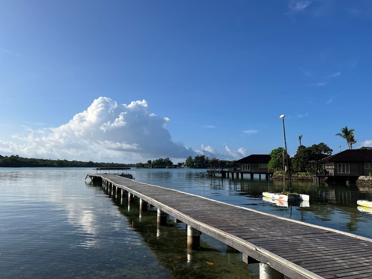 Wooden pier leading to a small boat dock with two houses at Warwick Le Lagon - Vanuatu Port Vila.