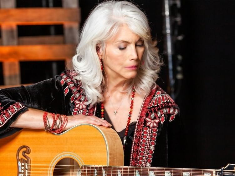 Emmylou Harris holding an acoustic guitar