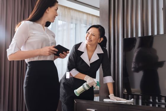 Lady cleaning a table in a room at Hotel Capitol Kuala Lumpur