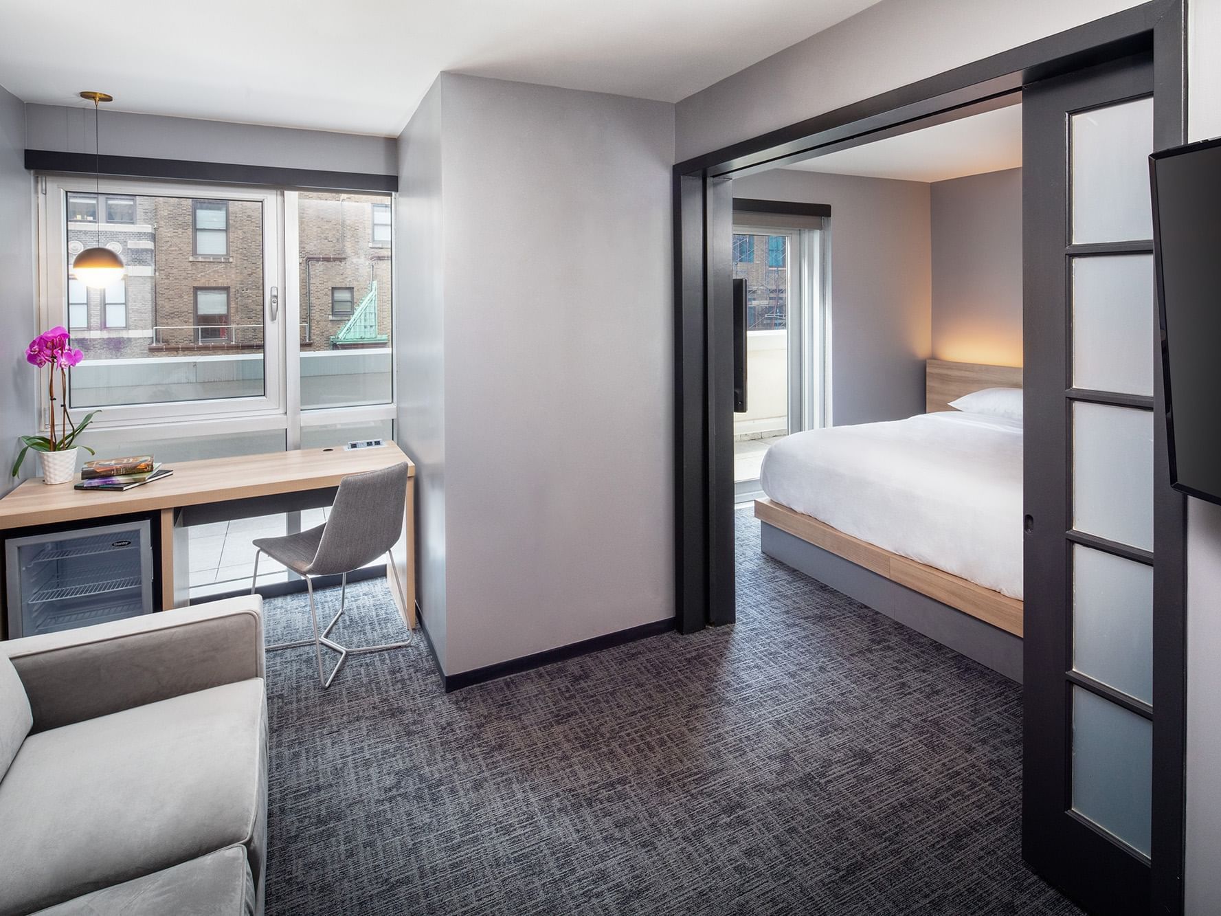 Work desk and lounger by the bed in Superior Suite with carpeted floors at Henn Na Hotel New York