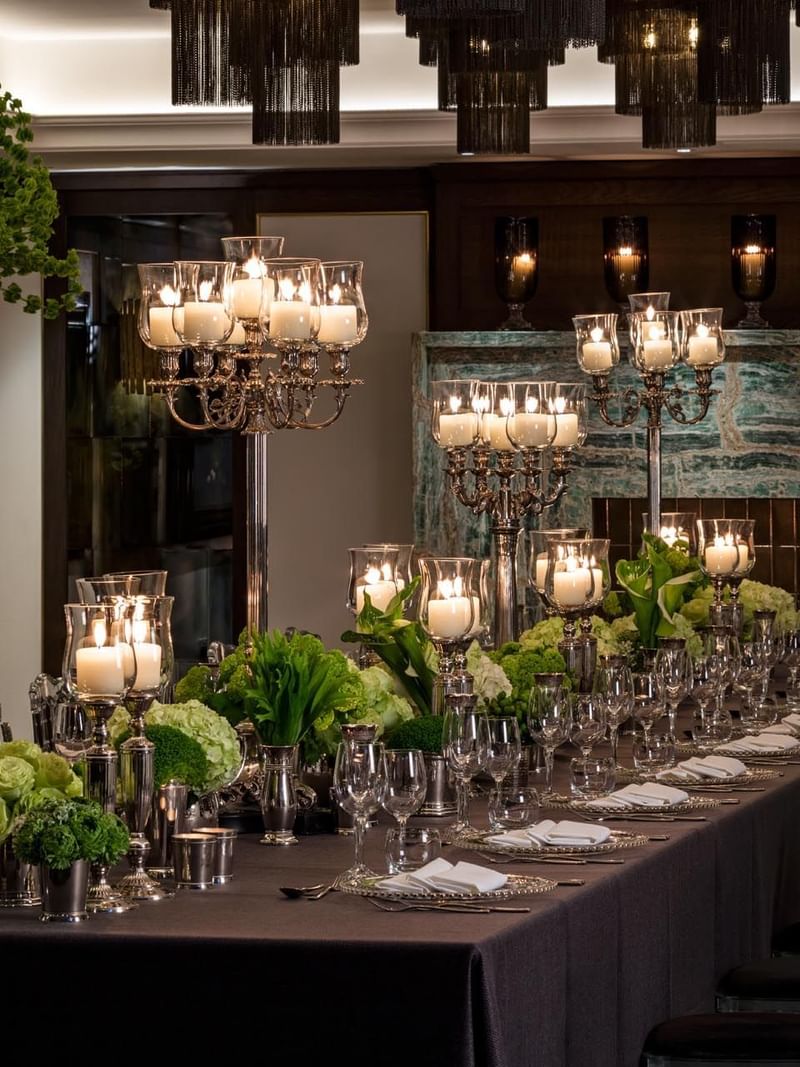 Elegantly set banquet table with greenery and candles, ready for guests at The May Fair Hotel, London.