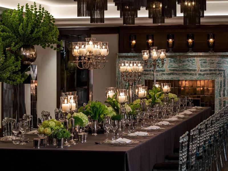 Elegantly set banquet table with greenery and candles, ready for guests at The May Fair Hotel, London.